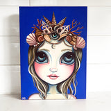 A painting on canvas of a mermaid wearing a crown on a royal blue background
